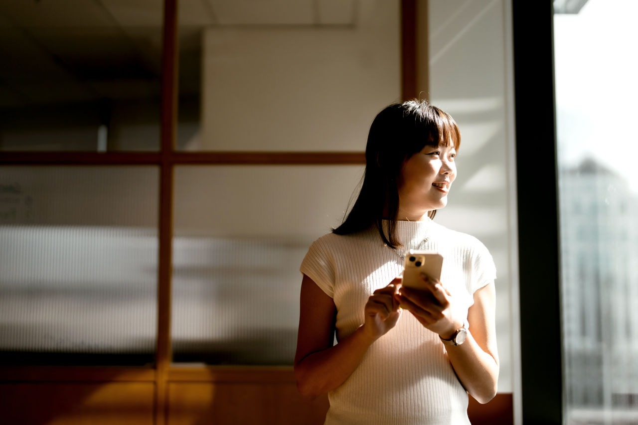An Asian Chinese businesswoman using smartphone in office
