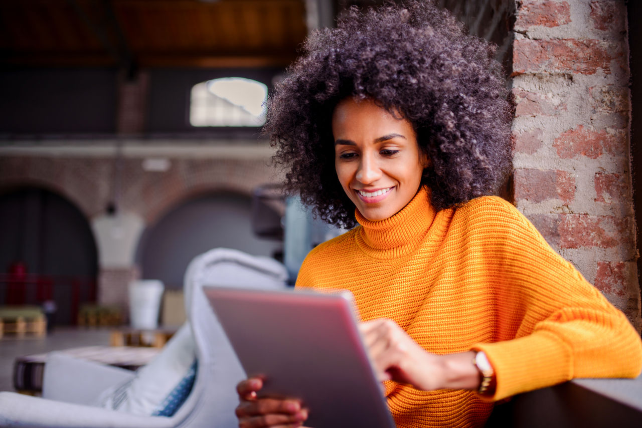 Smiling African American woman using digital tablet.